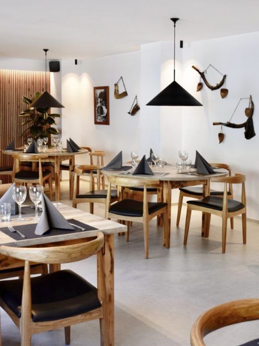 Comedor del restaurante del Hotel l'Aüt equipado con mesas y sillas con acabados de madera